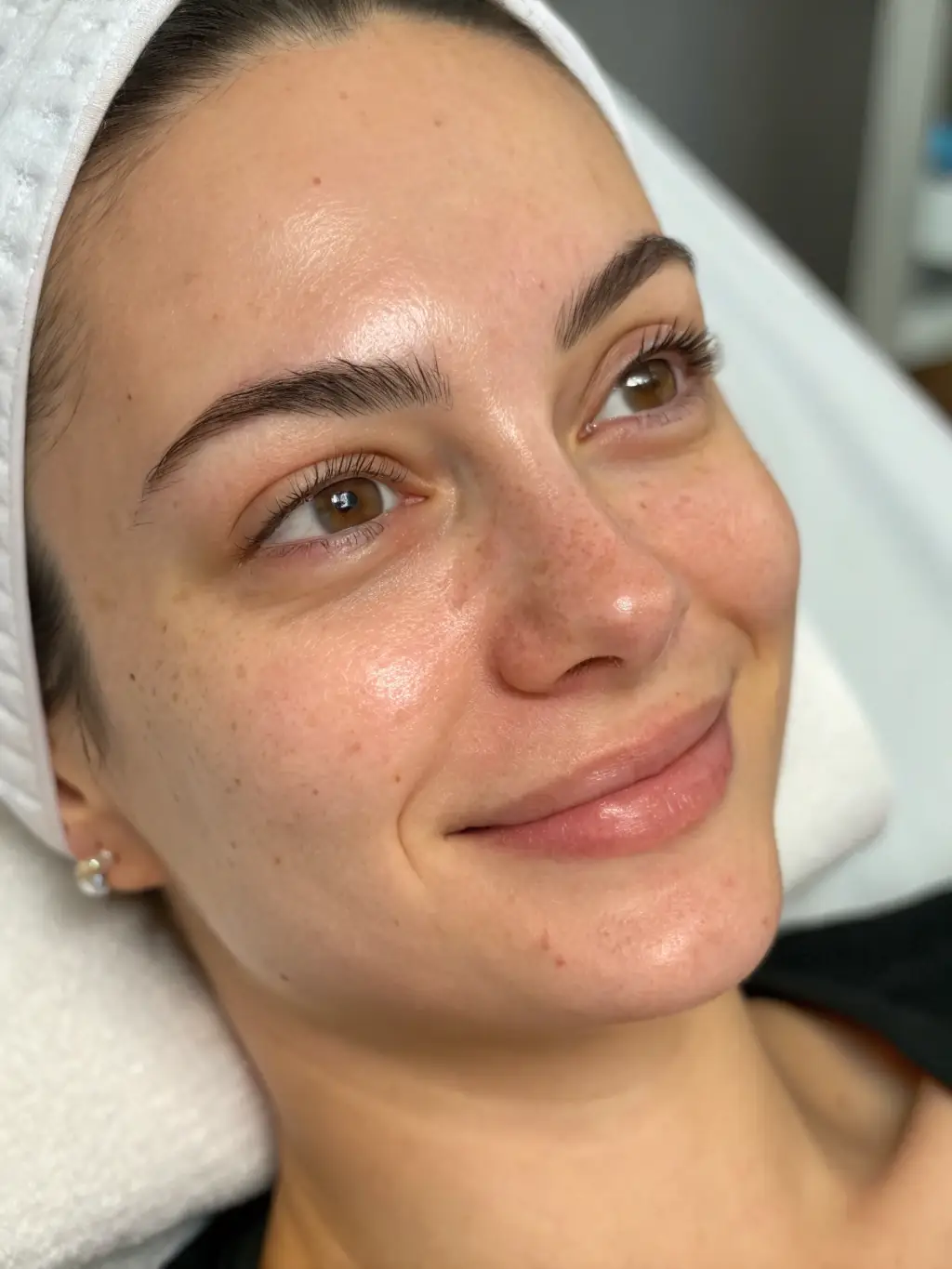 A close-up shot of a woman's face with clear, glowing skin, emphasizing the natural radiance achieved through all-natural skincare. The background is soft and blurred, highlighting the skin's texture.